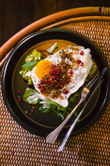 Avocado toast with egg on black plate