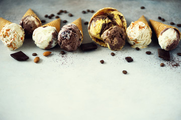 Chocolate and coffee ice cream in waffle cone with coffee beans on grey stone background. Summer food concept, copy space. Healthy gluten free ice-cream. Top view