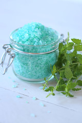 mint bath salt. salt with mint extract in  jar and fresh mint on a gray wooden  background.Pure Natural Cosmetics