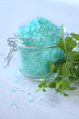 mint bath salt. salt with mint extract in glass jar and fresh mint on a gray wooden  background. Natural Cosmetics