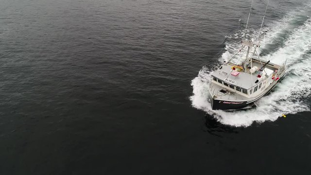 Aerial ocean commercial fishing boat fishing with lobster traps