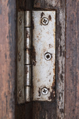 old hinge on wooden door or window, shallow depth of field