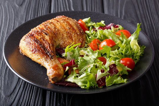 Homemade barbecue: grilled chicken leg with fresh vegetable salad close-up on a plate. horizontal