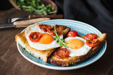 Breakfast toast with egg, arugula and roasted tomato, closeup view. Horizontal composition. Healthy eating, healthy lifestyle concept