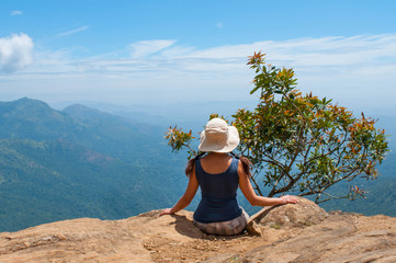 Fototapeta na wymiar Happy woman enjoying nature on top of mountain cliff