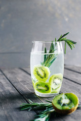 Refreshing water with kiwi is decorated with a branch of rosemary