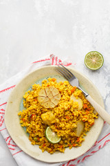Curry bulgur with vegetables in white plate, top view, copy space. Healthy vegan food concept.