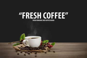 Hot coffee cup with fresh organic red coffee beans and coffee roasts on the wooden table and the black background with copyspace for your text.