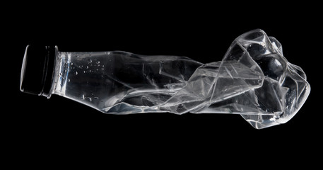 Empty used water bottle for recycling over dark background