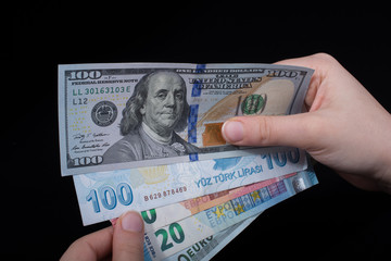 Hand holding American dollar  isolated on black background