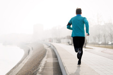 Determined sportsman fitness exercising by jogging outdoor