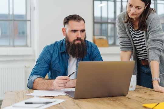 Two work colleagues working together on a laptop