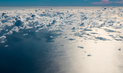 Fototapeta na wymiar Aerial view of clouds above calm ocean close to sunset.