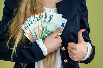 woman holding euro banknotes isolated on green