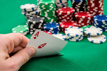 Close up of a poker player holding playing cards .