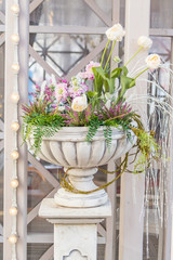 Blooming flowers in a large vase in the street on a sunny day, wedding decoration
