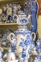 Fototapeta premium Colorful porcelain utensils and souvenirs in gzhel style at market. Traditional russian souvenir