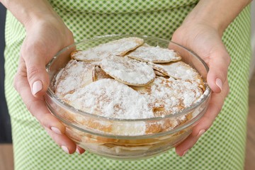 Homemade food, woman holding bowl with fresh pancakes sprinkled with powdered sugar