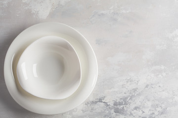 Beautiful vintage white empty plates on a gray background. Copy space, top view. Table setting background concept.