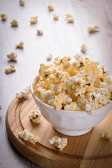 Salt popcorn on the wooden table, selective focus