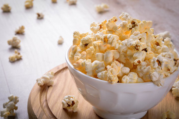 Salt popcorn on the wooden table, selective focus