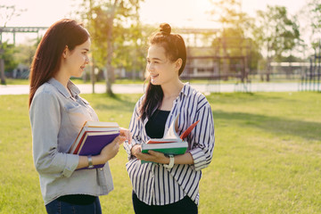 Young women together study reading book in university and knowledge at outside or park campus relaxing smile in summer season