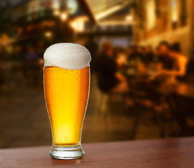 cold glass with beer on the background of a outside bar.