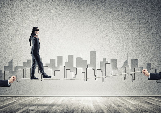 Business concept of risk support and assistance with man balancing on rope