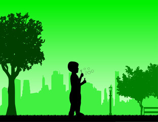 Boy blowing soap bubbles in park in spring silhouette, one in the series of similar images