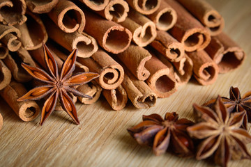  shelves of cinnamon and anise stars in dark backgrounds on a wooden background