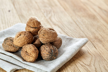 A stack of walnuts piled together and on rustic wooden background, shallow depth of field, selective focus