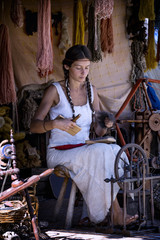 Fototapeta na wymiar Portrait of a young woman, carding wool at a street market