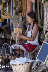 Portrait of a young woman, carding wool at a street market
