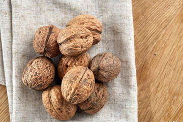 A stack of walnuts piled together and on rustic wooden background, shallow depth of field, selective focus