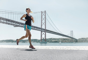 Blonde woman running training on the coastline near the Bridge u