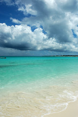 Naklejka premium Horizontal view of tropical turquoise Caribbean sea, white sand, and heavy stormy clouds. Copy space, tranquil atmosphere of a popular vacation destination, holiday paradise, secret beach