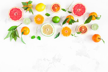 Fruit border. Colorful fresh fruits on white table. Orange, tangerine, lime, lemon, grapefruit. Flat lay, top view, copy space