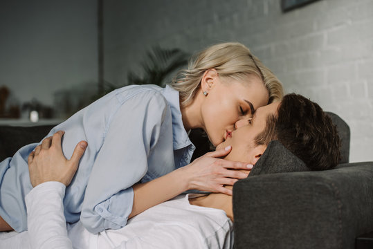 Sexy Couple Kissing On Sofa At Home