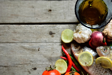 Raw fish with cooking mineral on wooden background