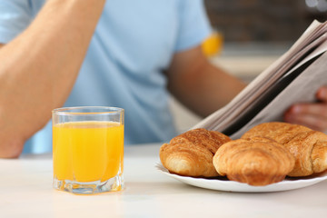 man in the kitchen eating a juice newspaper