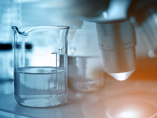 Microscope with laboratory glassware, blue tone 