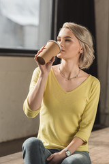 attractive girl drinking coffee from disposable coffee cup