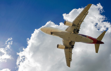The plane on a background of blue sky and white clouds.