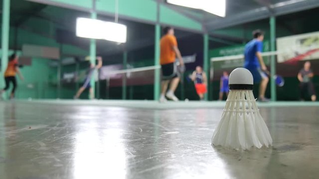 White shuttlecock laying on the floor and a blurred background of badminton practice.
Blurred background of badminton practice.
Badminton practice inside the gymnasium.