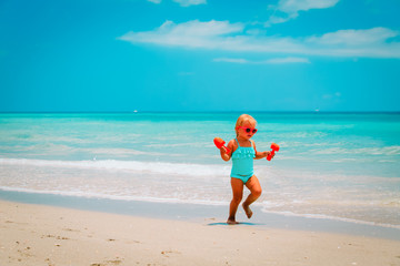 cute little girl play with sand on beach