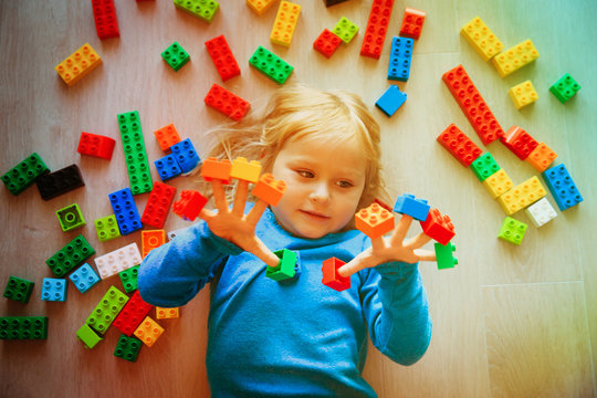 cute little girl play with plastic blocks