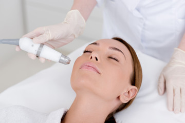 partial view of woman getting facial treatment in cosmetology salon