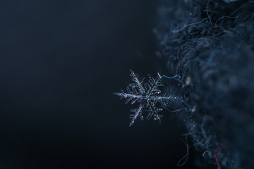 Beautiful snowflake, a single ice crystal in a sufficient size, falls through the Earth's atmosphere as snow. Often in shining hexagonal crystals shape. Taken In Paris during winter with shallow DOF.