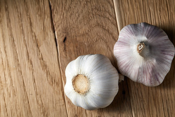 Close up view of two garlic bulbs arranged on a black piece of board, shallow depth of field, selective focus, macro