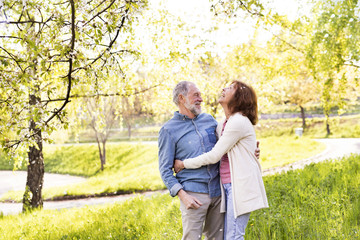 Beautiful senior couple in love outside in spring nature.